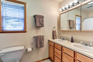 A bathroom with two sinks, a toilet, and a window with blinds. - Forest Views & Beach Access: Family Truckee Gem (Truckee)