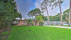 A residential property with a well-maintained lawn, a brick house, and a mobile home in the background. - St. Petersburg Escape - 3 Miles to the Beach! (St. Petersburg)