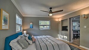 A bedroom with a bed, ceiling fan, and a view of the dining area. - St. Petersburg Escape - 3 Miles to the Beach! (St. Petersburg)