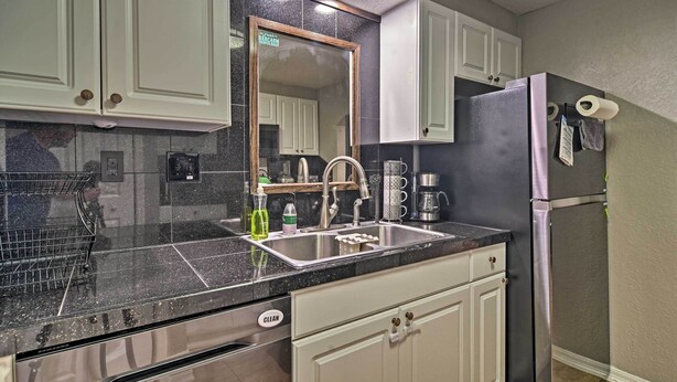 A kitchen with white cabinets, a stainless steel sink, and a refrigerator. - St. Petersburg Escape - 3 Miles to the Beach! (St. Petersburg)