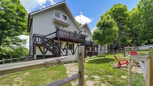 A two-story house with a balcony, a stone pathway, and a red chair in the yard. - 1 Mi to Beech Mtn Ski Resort: Home w/ Large Yard (Banner Elk)
