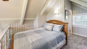 A bedroom with a sloped ceiling, a wooden bed frame, and a window with blinds. - 1 Mi to Beech Mtn Ski Resort: Home w/ Large Yard (Banner Elk)