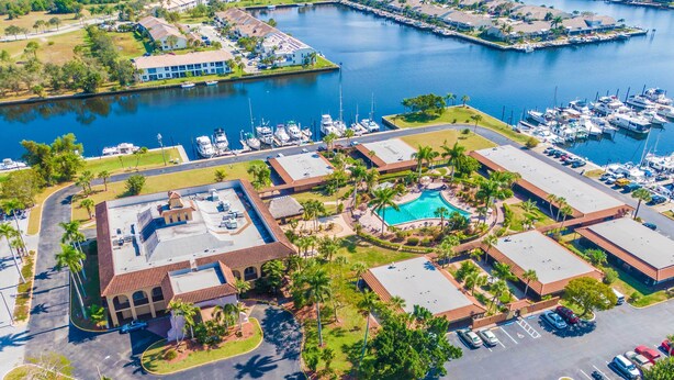An aerial view of a marina with boats, a swimming pool, and a parking lot. - Naples Studio w/ Resort Amenities - Near Marina! (Naples)