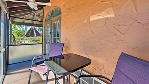A covered outdoor seating area with a ceiling fan, a table, and chairs. - Naples Studio w/ Resort Amenities - Near Marina! (Naples)