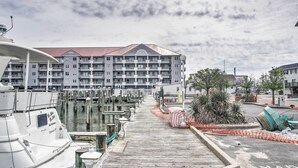 A marina with docked boats, a wooden walkway, and a multi-story building with balconies. - 2 Mi to Ocean City Boardwalk: Gem w/ Pool + Marina (Ocean City)