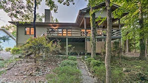A two-story building with a covered outdoor seating area and a stone pathway. - Hot Springs Village Home, Walk to Lake & Golf (Hot Springs Village)