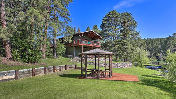 A lodge with a wooden deck, a gazebo, and a pond. - Creekside Rapid City Cabin w/ Deck on 30 Acres! (Rapid City)