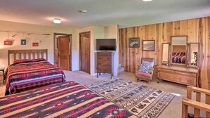 A bedroom with two beds, a dresser, a chair, and a television. - Creekside Rapid City Cabin w/ Deck on 30 Acres! (Rapid City)