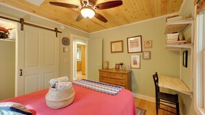 A bedroom with a bed, a wooden ceiling fan, a dresser, and a bookshelf. - Ski & Hike! Creekside Cabin 7 Mi to Linville Falls (Newland)