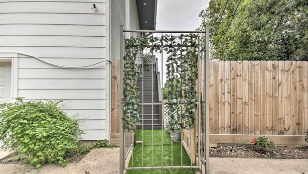 A gated entrance with a wooden fence and a staircase leading to a house. - Luxe, Modern Houston Apt - 1 Mile to The Galleria! (Houston)