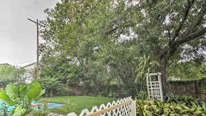 A backyard with a wooden deck, a small garden, and a white fence. - Luxe, Modern Houston Apt - 1 Mile to The Galleria! (Houston)