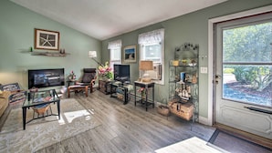 A living room with a television, seating, a fireplace, and a door with a view. - Ideal Narragansett Location w/ Furnished Deck! (Narragansett)