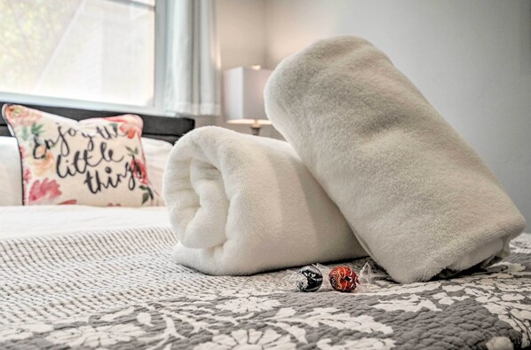 A neatly made bed with two white towels and two wrapped chocolates on a patterned bedspread. - Hurricane Getaway w/ Yard - 25 Mi to Zion! (Hurricane)