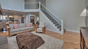 A spacious living area with a sofa, chairs, a coffee table, and a staircase. - Mountain-view Home < 15 Mi to Alta + Snowbird (Sandy)