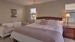 A bedroom with a large bed, a nightstand, a chair, and a ceiling fan. - Mountain-view Home < 15 Mi to Alta + Snowbird (Sandy)