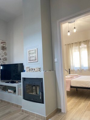 Una sala de estar con chimenea, televisor y una cita enmarcada en la pared.