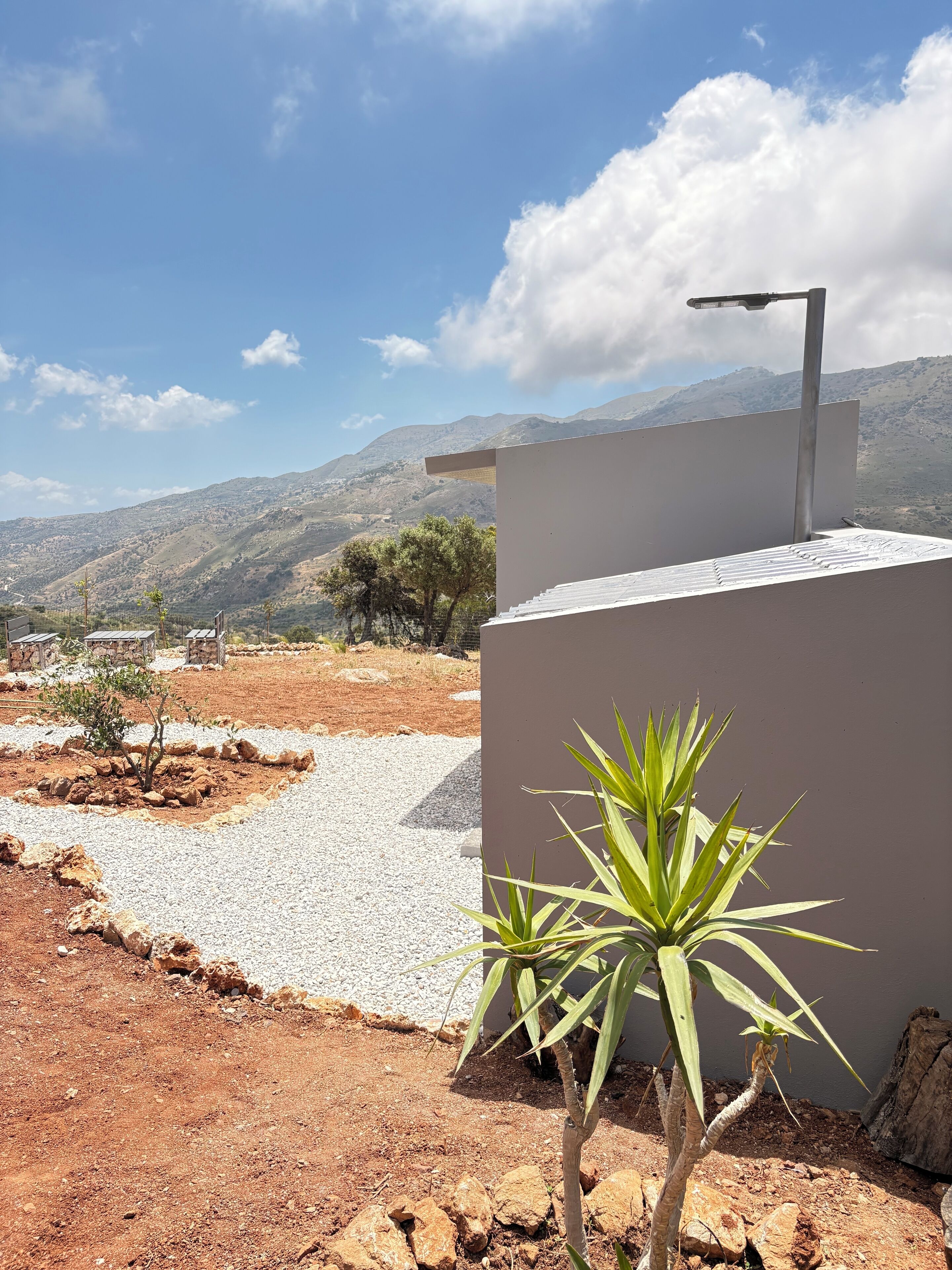 A modern building with a flat roof, a street lamp, and a view of distant mountains.