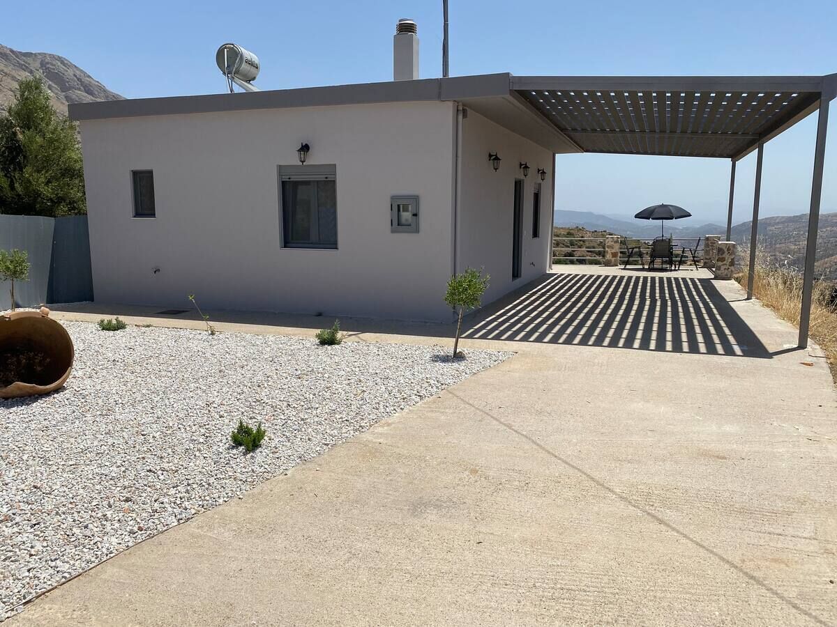 Il s’agit d’un bâtiment moderne doté d’un toit plat, d’une petite fenêtre et d’une porte. On y trouve également un espace extérieur abrité avec une table et des chaises.