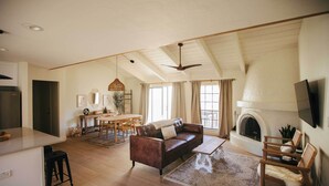 A spacious living room with a fireplace, a dining area, and a kitchen. - Scottsdale Condo w/ Patio, Pool & Hot Tub! (Scottsdale)