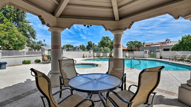 A covered outdoor area with a pool, chairs, and a table. - Scottsdale Condo w/ Patio, Pool & Hot Tub! (Scottsdale)