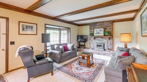 A living room with a fireplace, a sofa, a coffee table, and a television. - Family-friendly West Chester Twp Home w/ Pool! (West Chester)