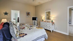 A bedroom with a bed, dresser, mirror, and ceiling fan. - Cape Coral House w/ Private Dock, Pool & Bar! (Cape Coral)