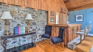 Un intérieur en bois avec un mur en pierre, un espace bar et des sièges.