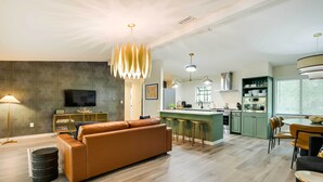 A modern living room with a sofa, a TV, and a patterned wall. - Riverfront Cottage in Homosassa: 'chateau Relaxo' (Homosassa)