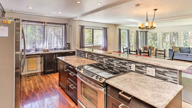 A modern kitchen with a central island, stainless steel appliances, and large windows. - Vibrant Weaverville Escape w/ Deck & Creek! (Weaverville)