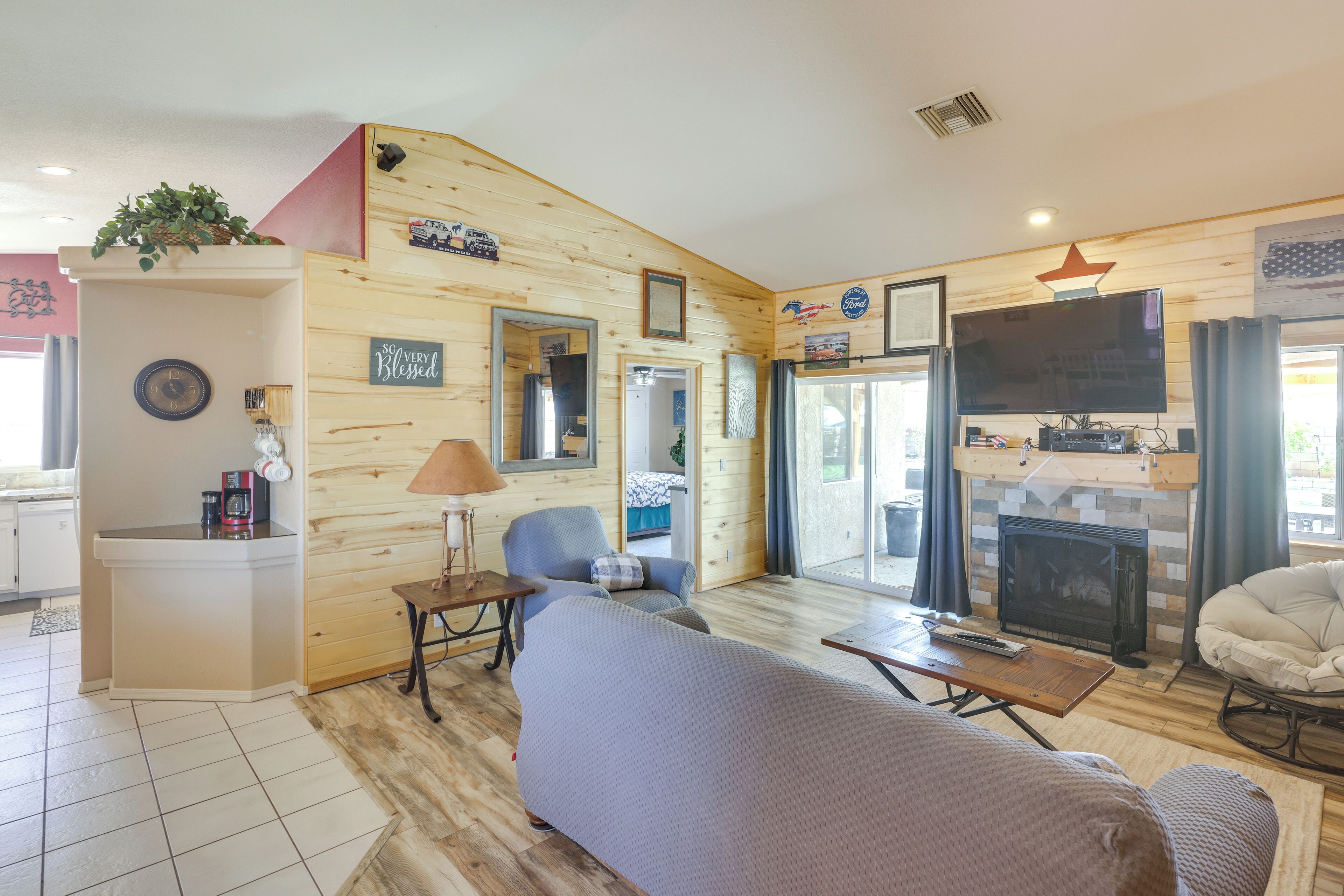 A cozy cabin-style room with a fireplace, a television, and a comfortable seating area.