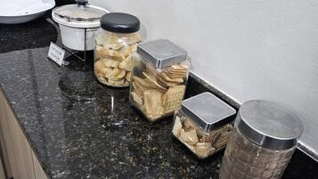 A kitchen counter with jars of snacks and a metal container.