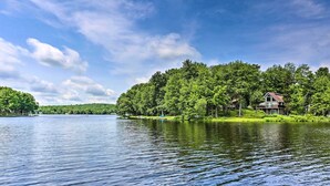 A lakeside property with a large house surrounded by dense trees. - Fire Pit & Grill: 'woodside Nest' in Pocono Lake! (Pocono Lake)