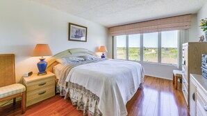 A bedroom with a bed, bedside lamps, a dresser, and a window with a view. - Atlantic City Area Vacation Rental w/ Pool Access! (Brigantine)
