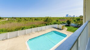 A swimming pool with a view of a city skyline and a grassy area. - Atlantic City Area Vacation Rental w/ Pool Access! (Brigantine)