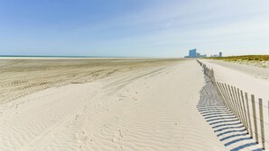 A sandy beach with footprints and a wooden fence. - Atlantic City Area Vacation Rental w/ Pool Access! (Brigantine)