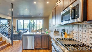 A modern kitchen with wooden cabinets, a stainless steel stove, and a large island. - Angel Fire Home w/ Hot Tub < 1 Mi to Ski Slopes! (Angel Fire)