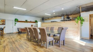 Un comedor con suelo de madera, una mesa larga y seis sillas.