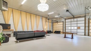 Un espacio interior amplio con un sofá grande, un banco de madera y un ventilador.