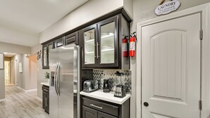 Una cocina moderna con electrodomésticos de acero inoxidable, lavavajillas integrado y cafetera.