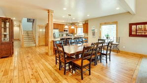A spacious kitchen with wooden cabinets, a dining area with a large table and chairs, and a staircase leading to another level. - Sunriver Group Getaway: Explore Deschutes Forest! (Bend)
