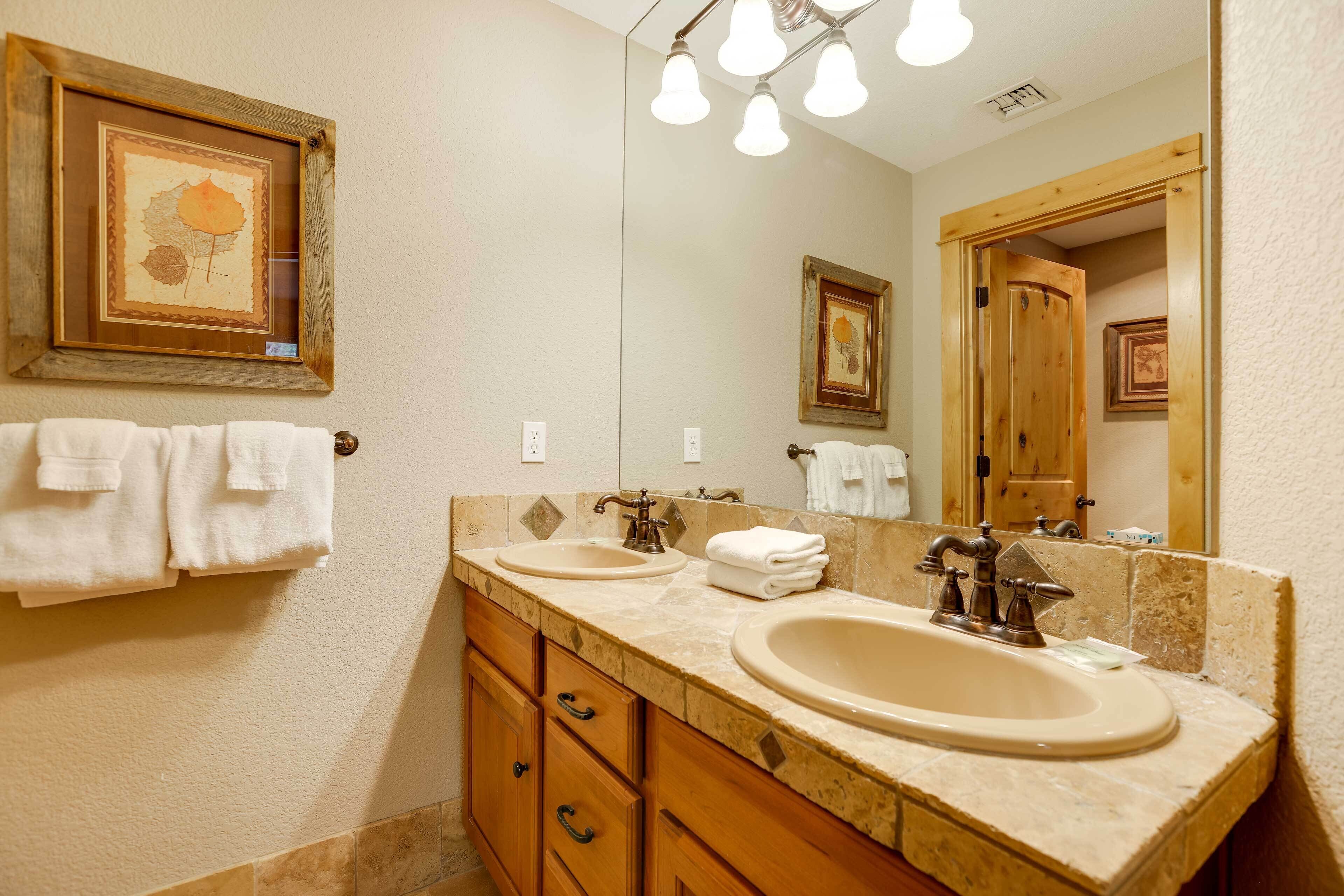 A bathroom with two sinks, wooden cabinets, and a large mirror.