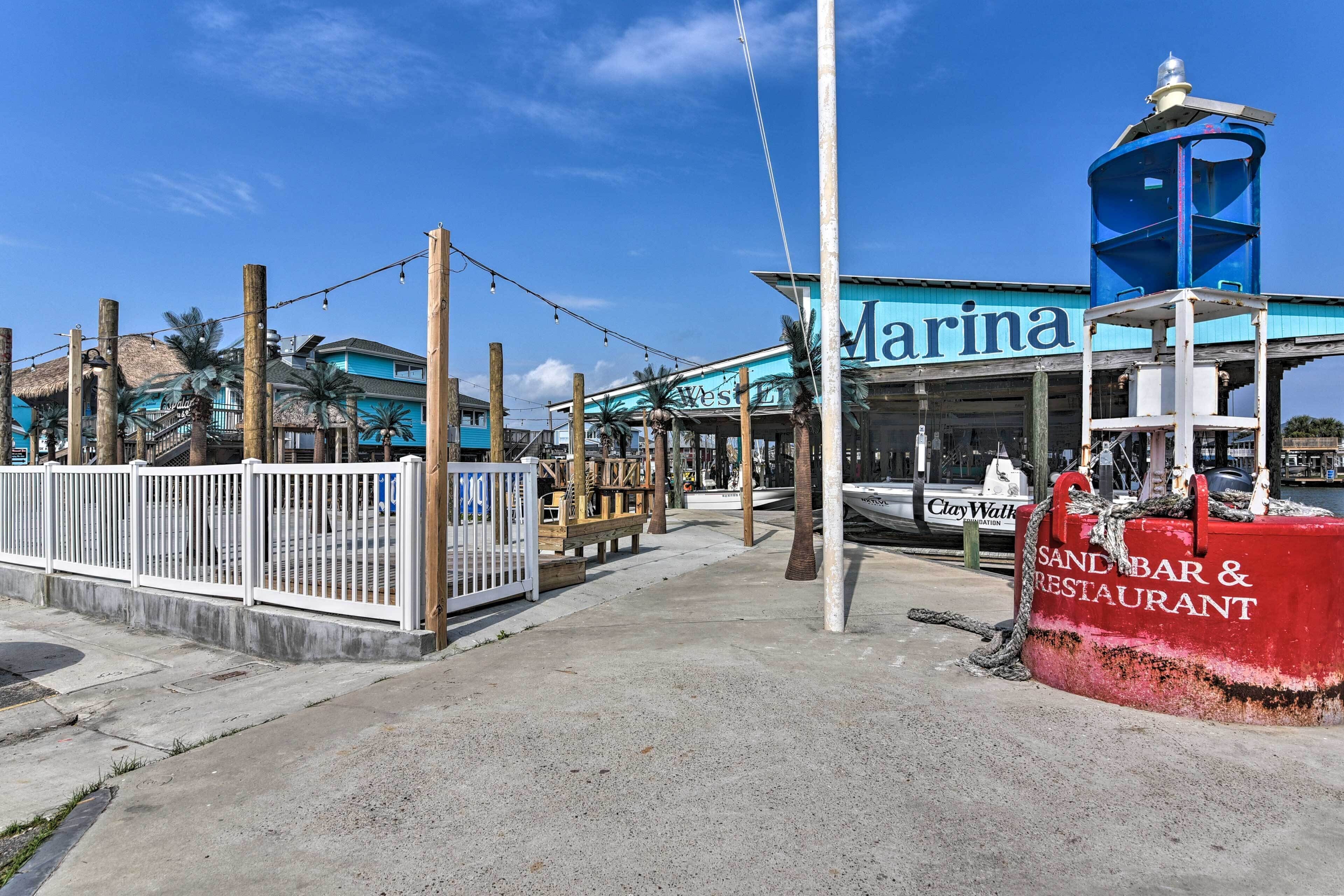 A beachside restaurant named 'Marina' with a blue and white color scheme, a sandy bar area, and a lifeguard tower.