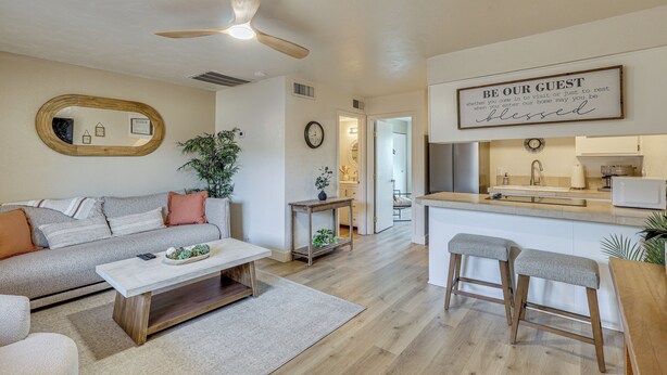 Un salon moderne avec un canapé, une table basse et un ventilateur de plafond.