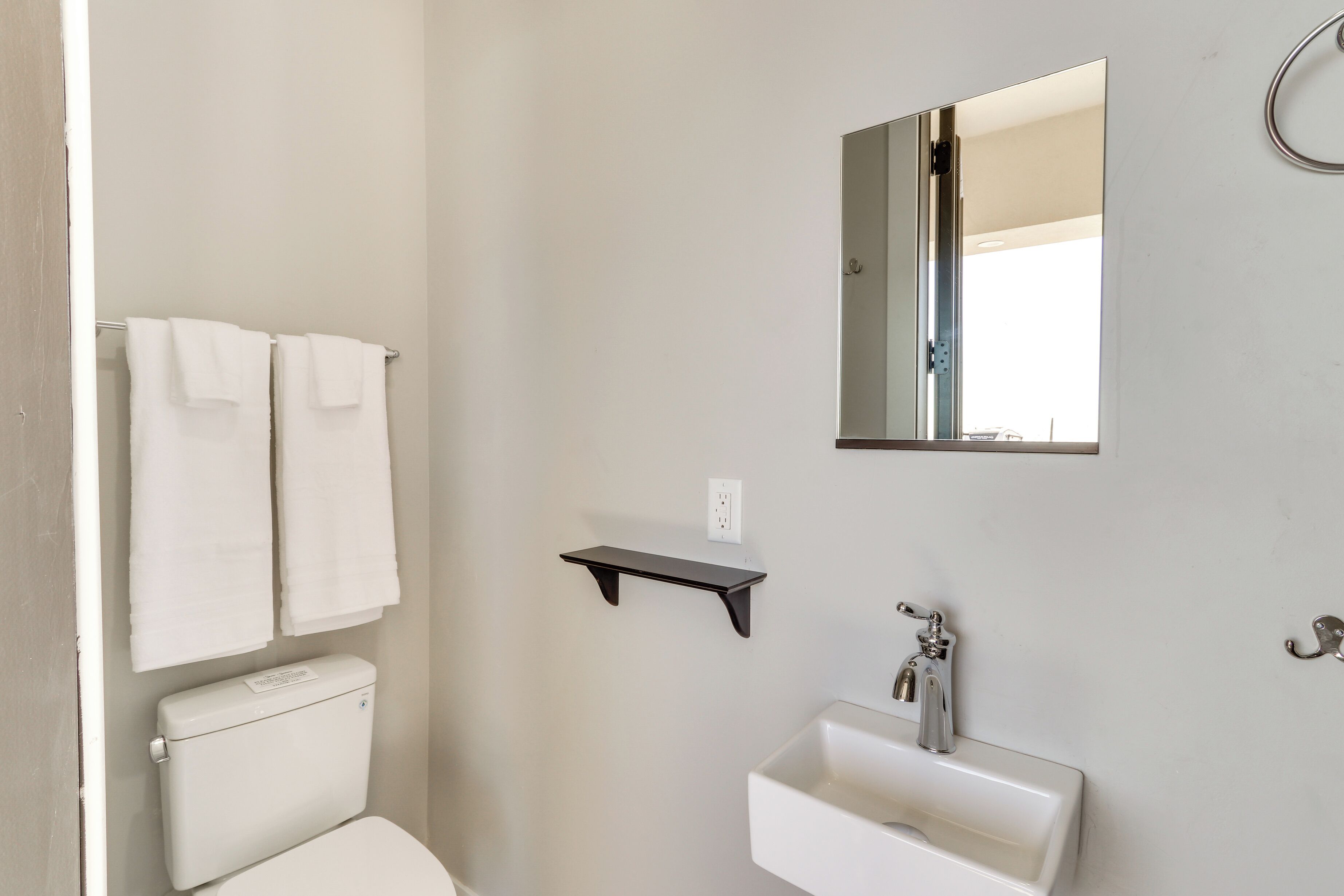A bathroom with a toilet, sink, and towel rack.