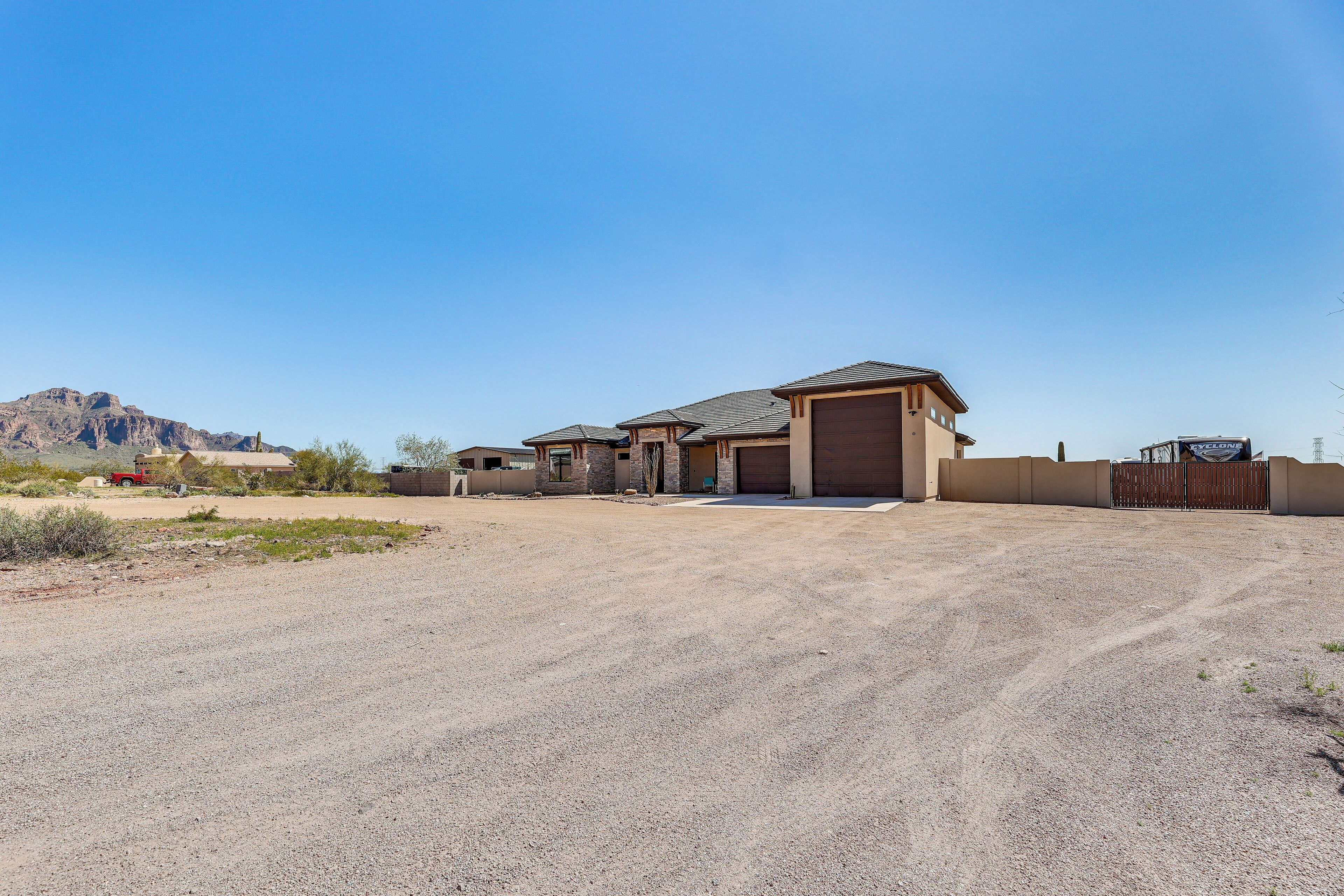 A residential property with a garage, a driveway, and a mountain in the background.