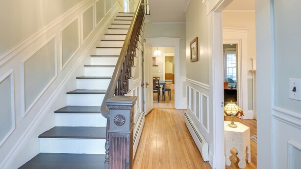A staircase with white walls and a wooden floor leading to a dining area. - Charming Bangor Home w/ Deck < 1 Mi to Downtown (Bangor)