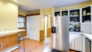 A modern kitchen with a stainless steel refrigerator, white cabinetry, and a wooden countertop. - Charming Bangor Home w/ Deck < 1 Mi to Downtown (Bangor)