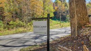 A sign for BOSECAMP with a natural backdrop of trees and a road. - Bryson City Tiny Cabin w/ Deck Near River Access! (Bryson City)