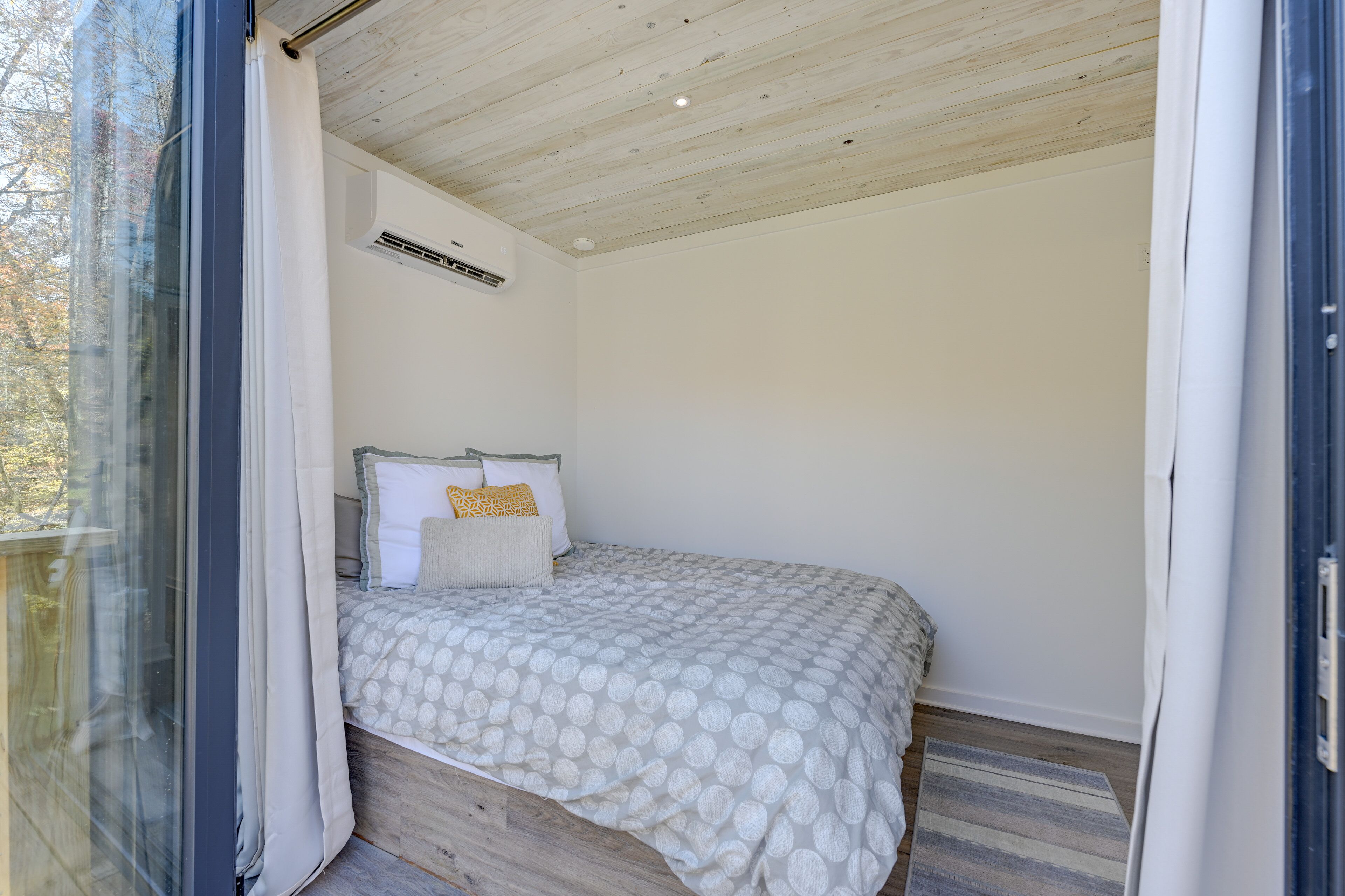 Ein Schlafzimmer mit Bett, Kissen und einem Fenster.