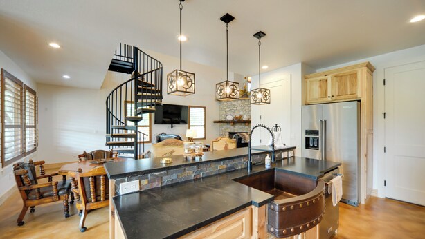 A spacious kitchen with a central island, a spiral staircase, and pendant lighting. - Horseshoe Bay Resort Home ~ 6 Mi to Lake Lbj! (Horseshoe Bay)